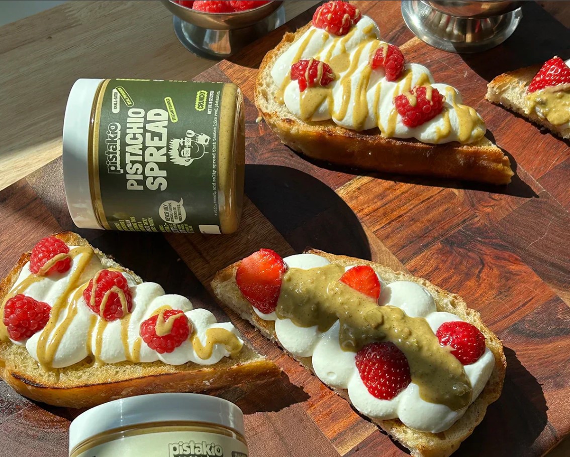 Pistachio cream spread thickly on toasted bread with crushed pistachios on top